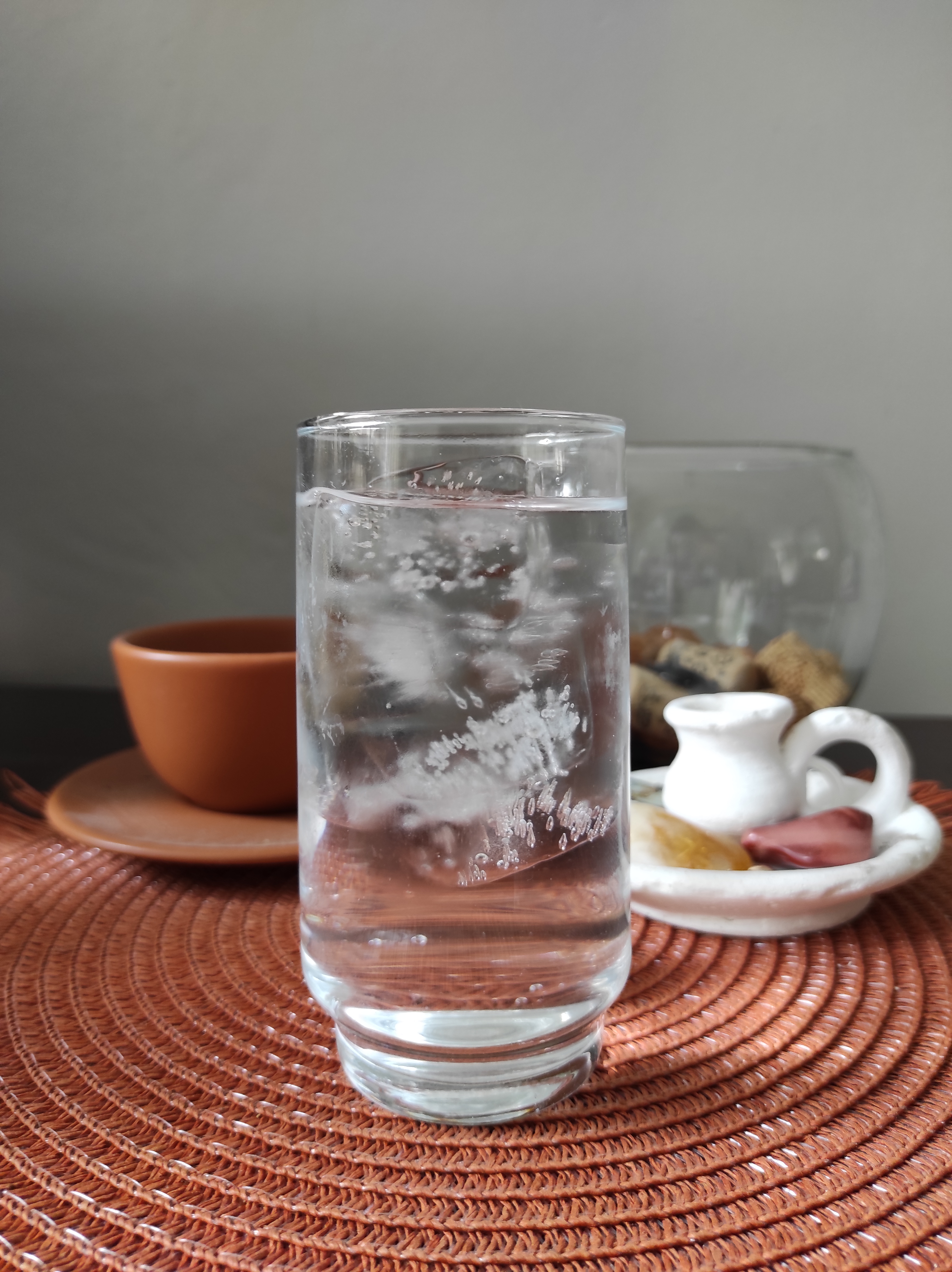 Copo com água e cubos de gelo dentro.